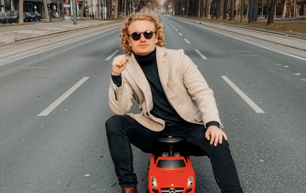 Dr. Bohl on a red ride-on toy car in the middle of an empty street