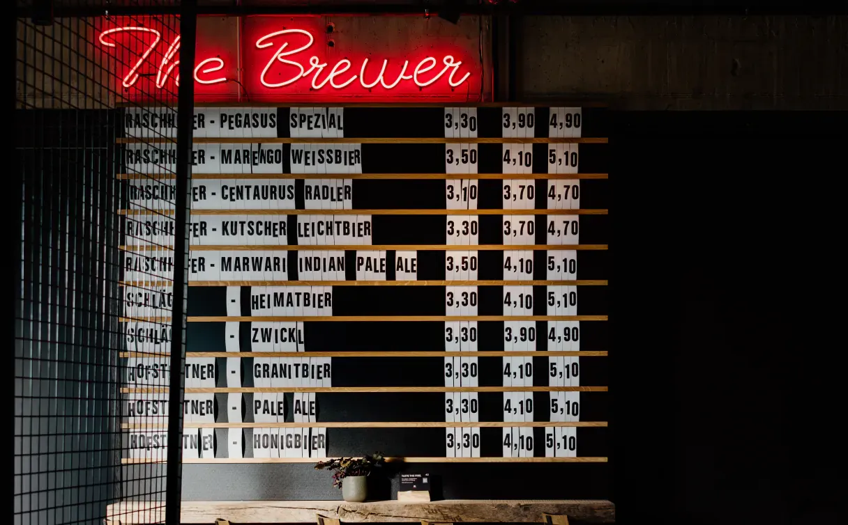 Biertafel unter der Leuchtschrift „The Brewer“